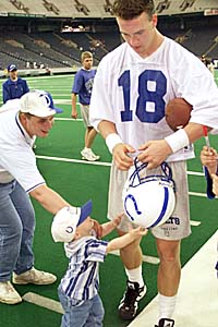 Peyton Manning signing for a young fan